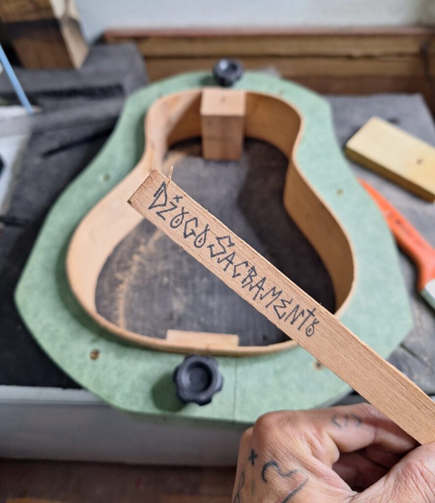 Assinatura do Luthier Diogo Sacramento na madeira de cedro que será colada na estrutura do instrumento.